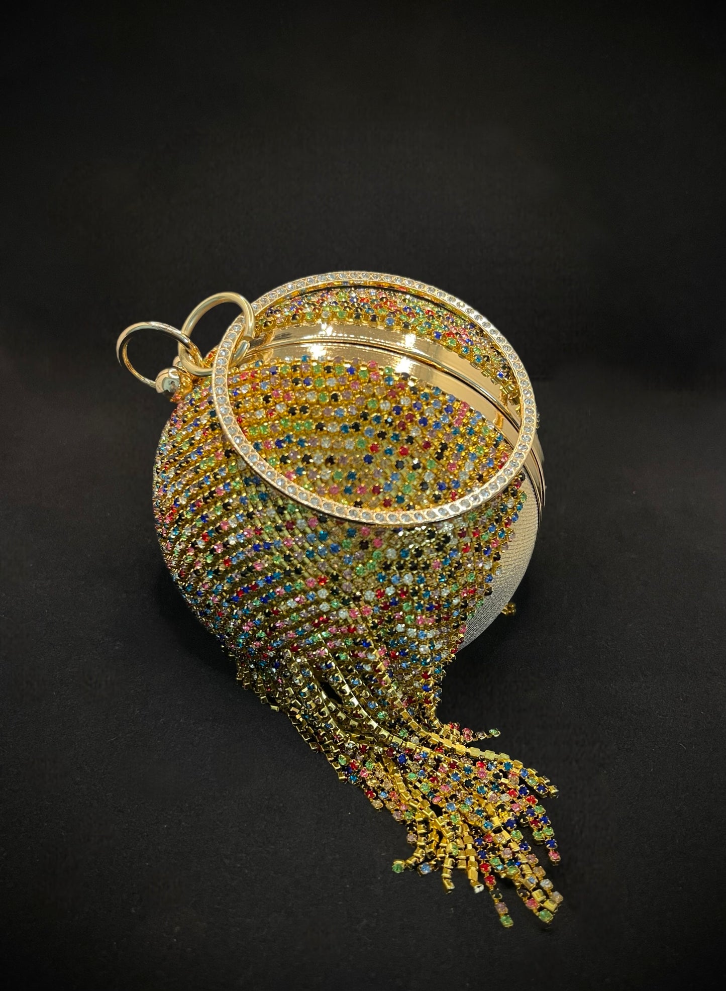 Bolso de mano bola circular con pedreria colgante de colores.