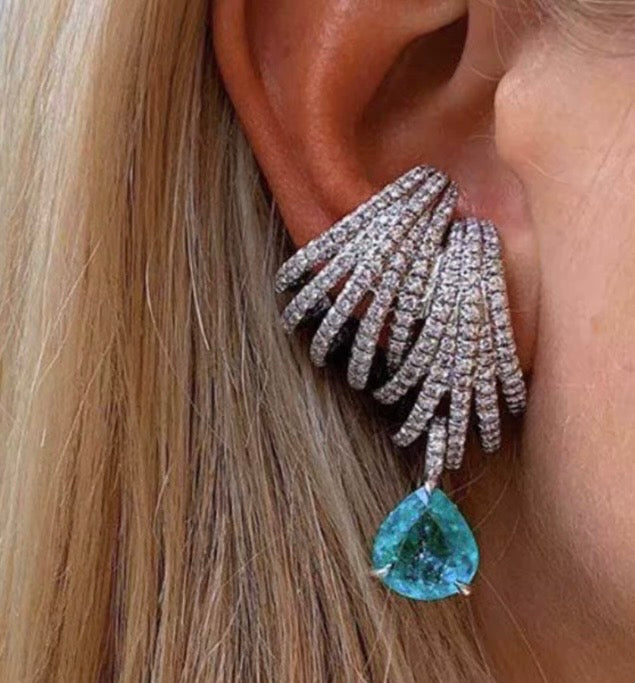 Aretes de joyería de lujo pedreria blanca, tonos plateados y detalle de piedra color Aqua.