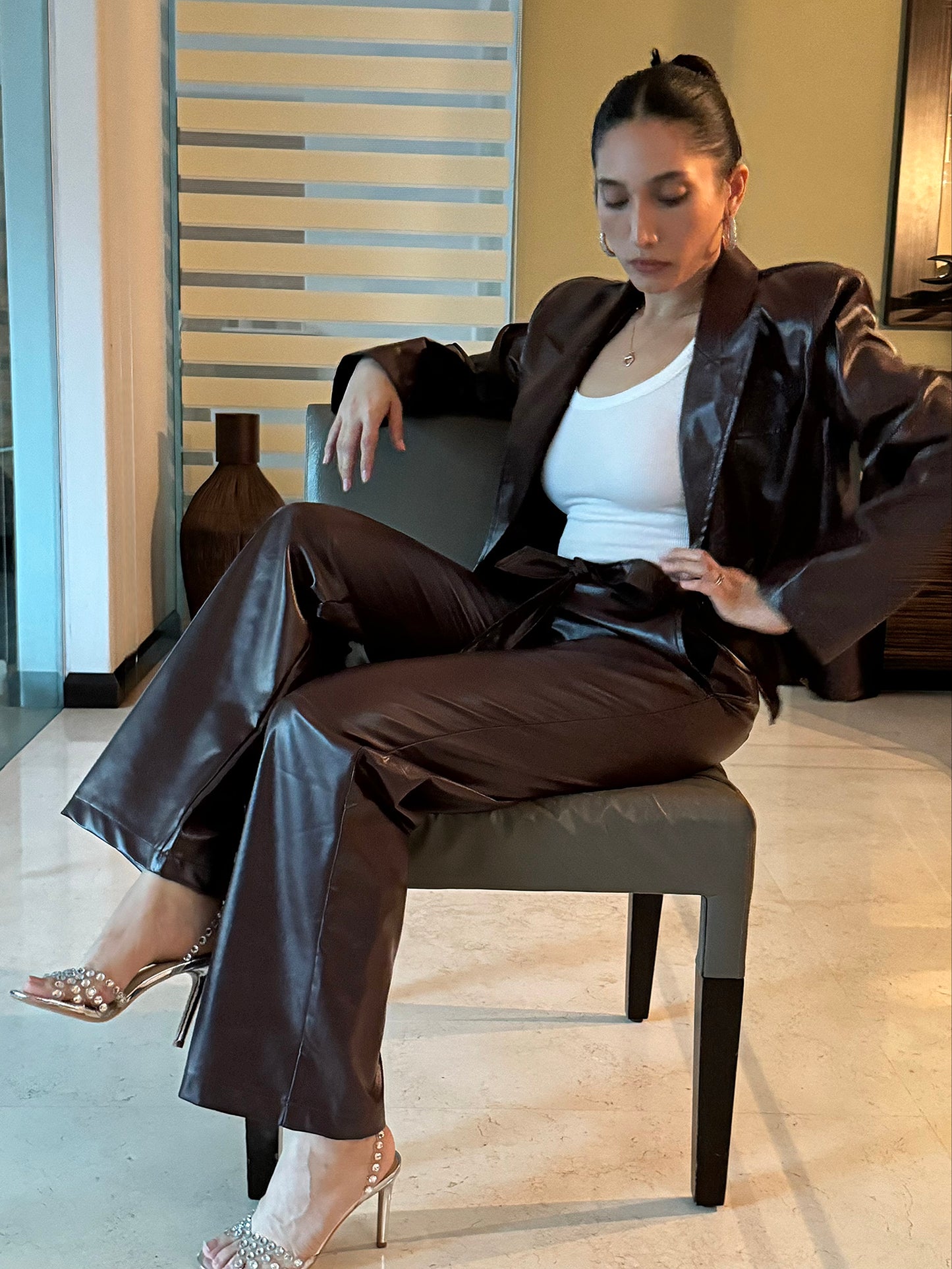 Conjunto de dos piezas de cuero en blazer y pantalón tono marrón.