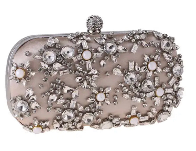 Clutch con perlas, piedras de distintos tamaños en tono nude y gris.