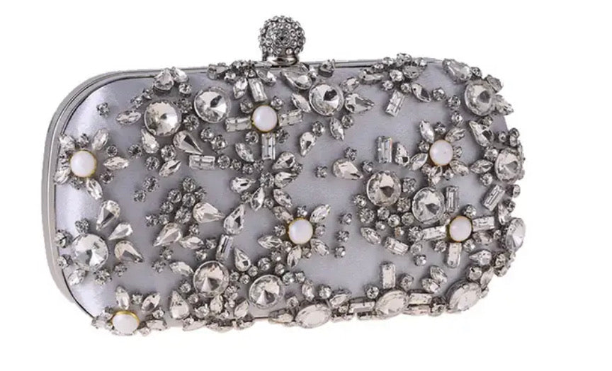 Clutch con perlas, piedras de distintos tamaños en tono nude y gris.