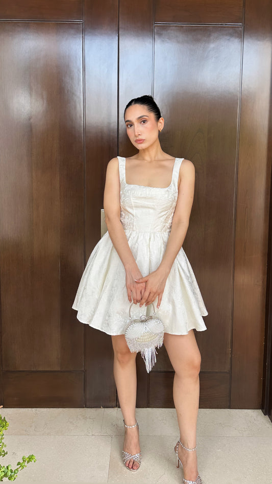 Vestido coctelero blanco sin mangas.