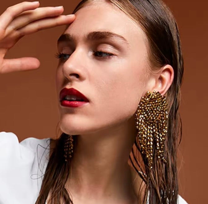 Aretes oversized de pedreria en tono dorado/cobre.