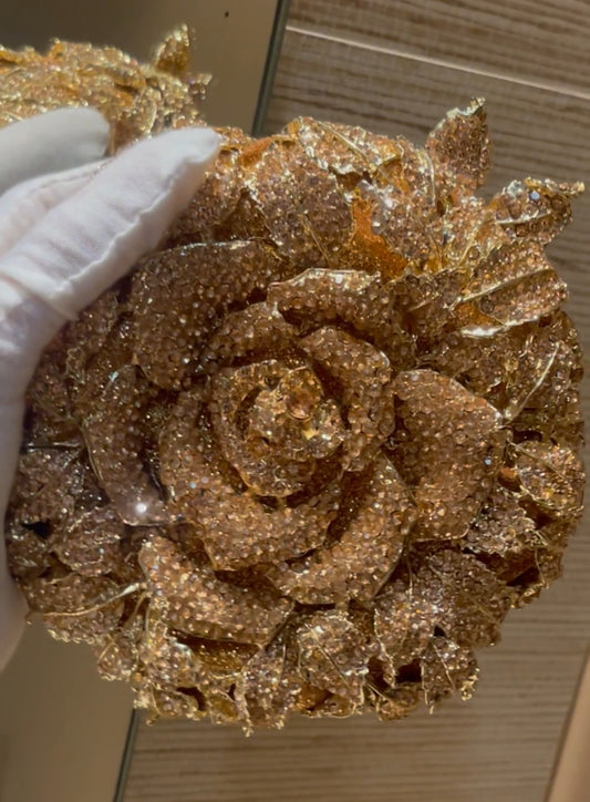 Clutch en forma de rosa, con pedrería en tono dorado y plata