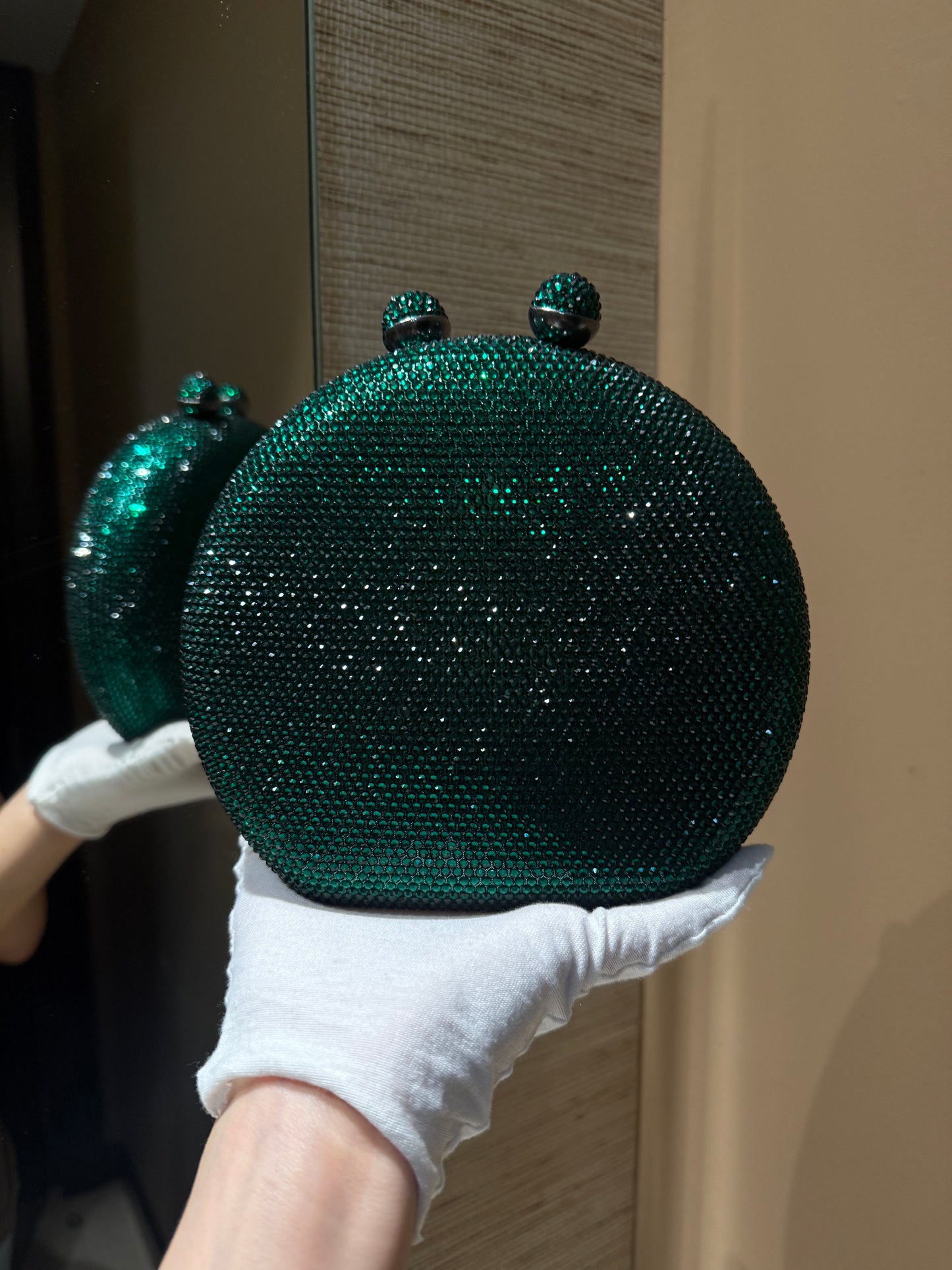 Bolso de mano forma redonda  con pequeños diamantes.