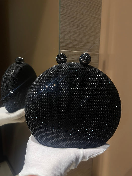 Bolso de mano forma redonda  con pequeños diamantes.