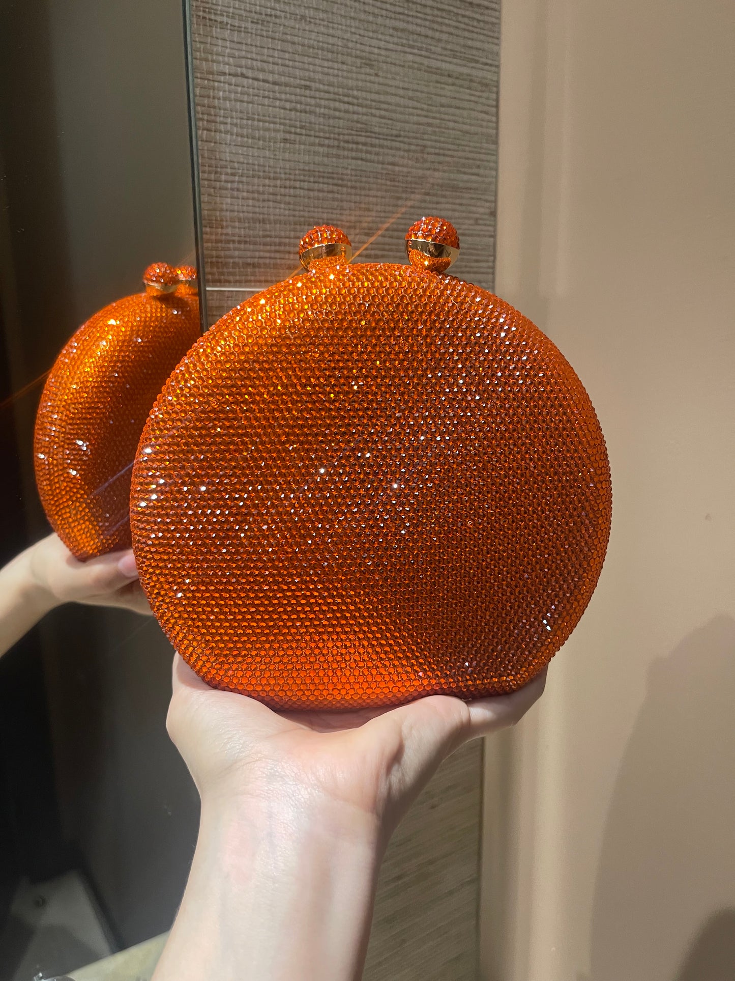 Bolso de mano forma redonda  con pequeños diamantes.