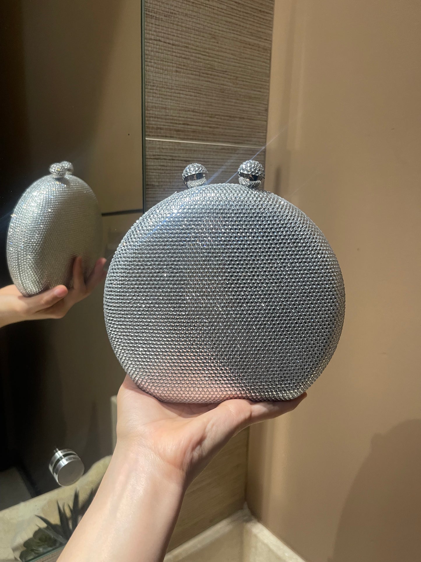 Bolso de mano forma redonda  con pequeños diamantes.