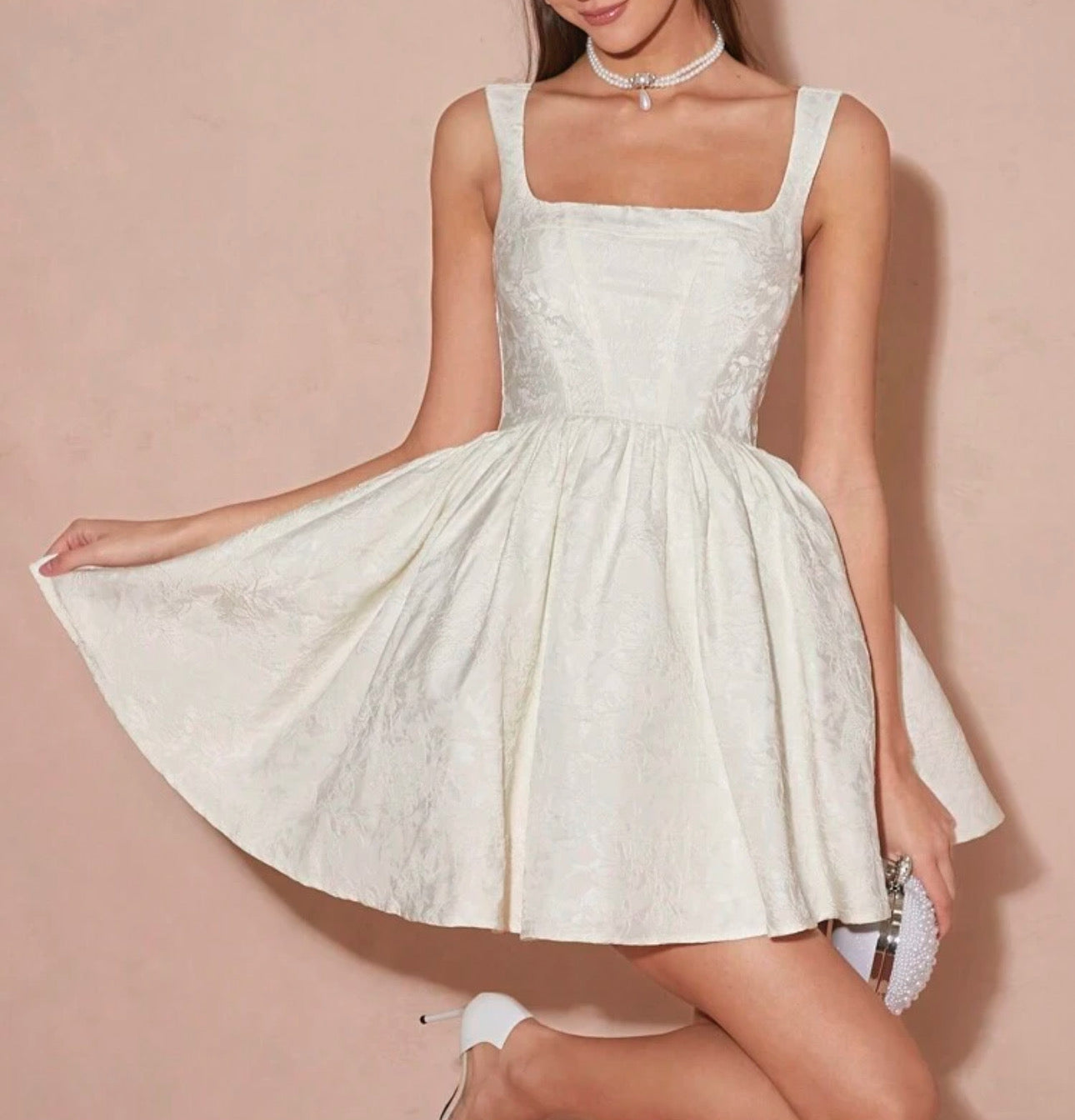 Vestido coctelero blanco sin mangas.