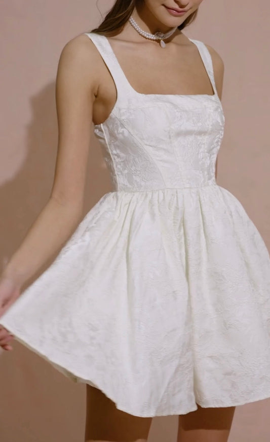 Vestido coctelero blanco sin mangas.