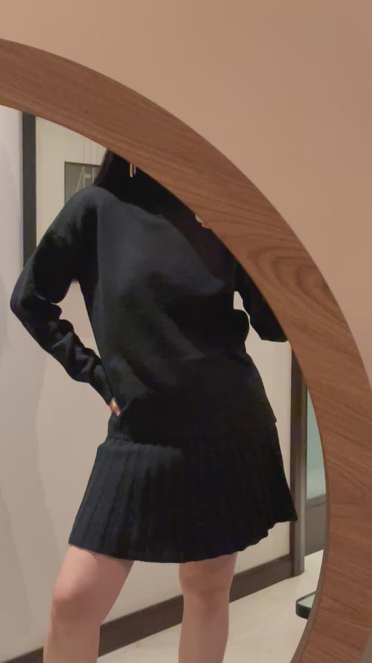 Conjunto de falda y suéter de cuello en tono negro, material punto