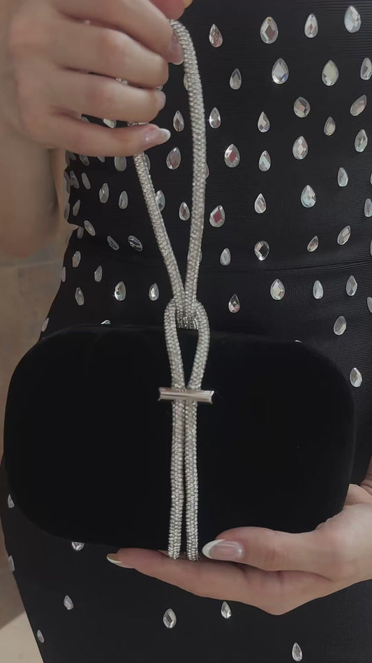 Black clutch aterciopelado en tono negro con detalle de listón en piedras